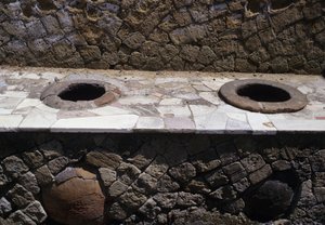 カウンターにボウルがセットされたサーモポリウム（スナックバー）の復元された遺跡 作： Roman